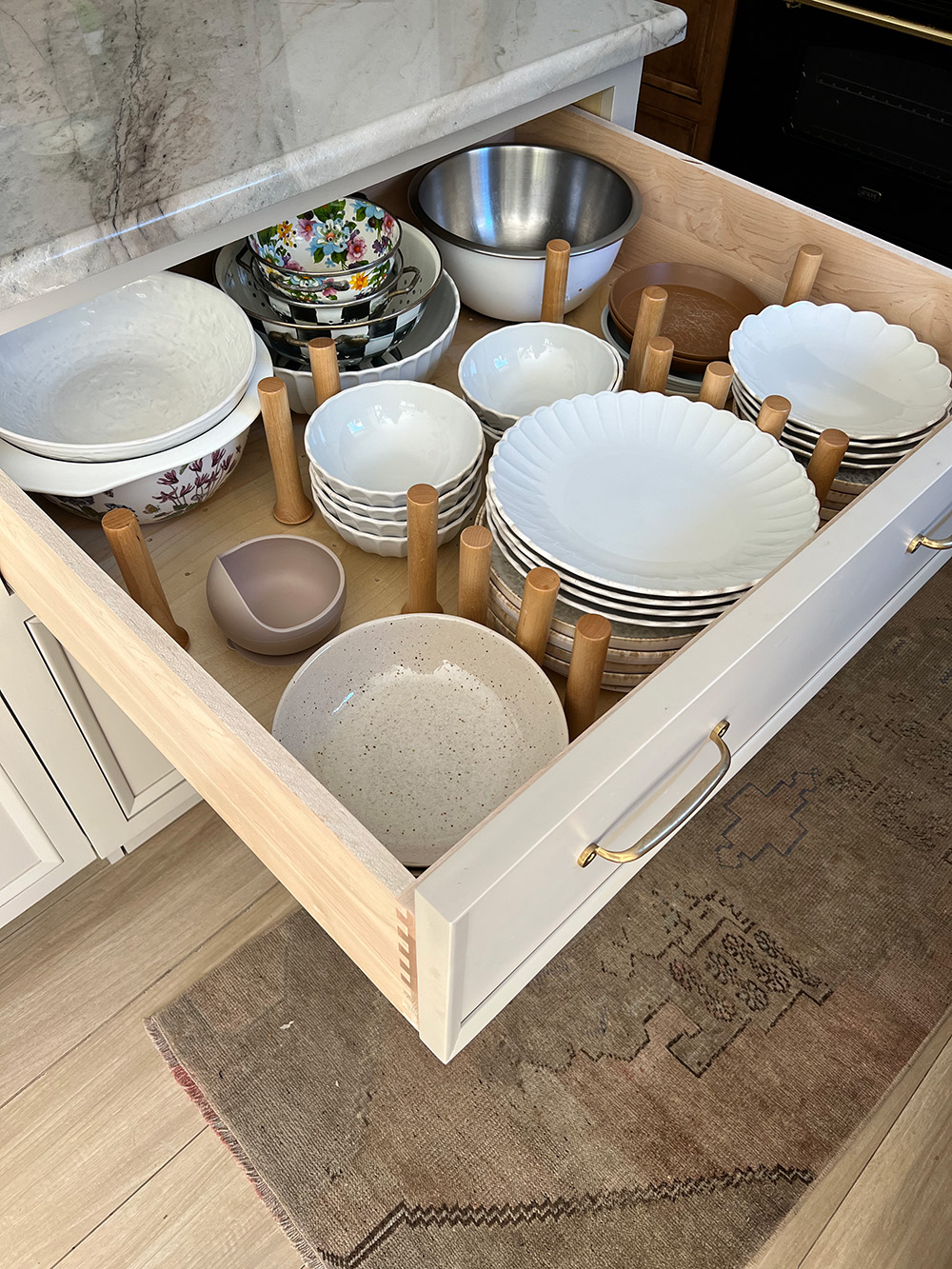 Wooden kitchen cabinet with ceramic plates and pots in kitchen in